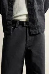 Jeans de corte relajado y pierna recta, confeccionados en denim de algodón rígido. Presentan tiro medio, cierre frontal con cremallera y botón, y diseño clásico de cinco bolsillos.