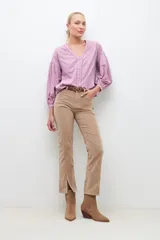 Blusa lila con bordados, de mangas largas abullonadas y cuello en V.