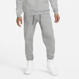 Pantalón de jogging Jordan Essentials Fleece, color gris melange, con cintura elástica ajustable mediante cordón negro, bolsillos laterales y logo Jumpman bordado en la pierna izquierda.