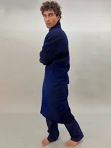 Tapado oversize desestructurado de lana merino afieltrada, teñido en degradé azul y negro. Tiene bolsillos laterales, cierre con broches ocultos y puños amplios que cubren la mano.