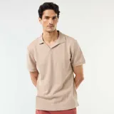 Remera polo de manga corta en color beige, confeccionada en tejido con textura de nido de abeja, con cuello camisero y escote en V.