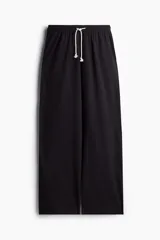 Pantalón de jogging negro de corte amplio, con cintura elástica ajustable con cordón y bolsillos laterales.