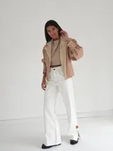 Campera oversize de cuero tostado con solapas y forro interno de corderito sintético azul marino, mangas anchas y detalles de costuras trenzadas.
