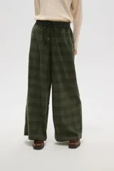Pantalon de corte ancho y tiro alto, confeccionado en tela con estampado a cuadros en tonos verdes. Presenta cintura elástica con cordón de ajuste frontal.