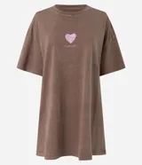 Camisón corto de algodón con efecto desteñido (acid wash), cuello redondo y mangas cortas. Presenta un pequeño estampado frontal de corazón en tono rosado con texto debajo.