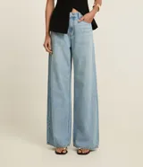 Pantalón de jean modelo wide leg con cintura alta, bolsillos laterales y cierre frontal con botón y cremallera. Confeccionado en algodón índigo de corte estructurado.
