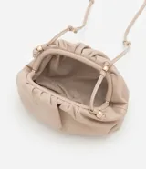 Cartera transversal pequeña color beige, confeccionada en poliuretano con diseño fruncido y asa fina de cordón con detalles metálicos.
