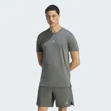 Remera deportiva Adidas Designed For Training de color gris, con cuello redondo, mangas cortas y tecnología AEROREADY para absorción de humedad. Presenta logo de la marca en el pecho y aberturas en los dobladillos laterales.