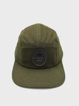 Gorro verde militar con visera plana y parche circular negro con logo de montaña.