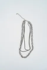 Collar doble de cadena plateada, compuesto por una cadena de eslabones gruesos y una cadena tipo serpiente más fina, con cierre de mosquetón y cadena de alargue.