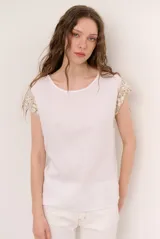 Blusa de lino color blanco con detalles de crochet en tono verde militar en los hombros, cuello redondo y manga corta.