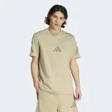 Remera Adidas de corte clásico y cuello redondo, color beige, con logo de la marca estampado en el centro del pecho y detalles gráficos en las mangas. Confeccionada en algodón fresco con protección UV.