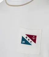 Remera de algodón color crudo, con cuello redondo y manga corta. Presenta un bolsillo en el pecho con estampa náutica y lettering "M.R.F.".