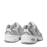 Championes New Balance 530 de estilo retro running, confeccionados con malla transpirable blanca y detalles metalizados en tono plateado. Cuentan con la icónica letra "N" en los laterales, suela amortiguada y cordones blancos.