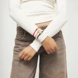 Pulsera ajustable de hilo elástico rojo con un dije central de corazón dorado y un cierre deslizante dorado.