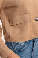 Chaqueta corta de gamuza sintética color tostado, con cuello clásico, cierre frontal de botones y bolsillos delanteros con solapa.