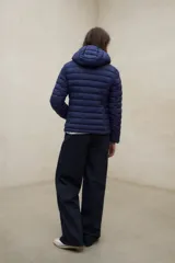 Campera puffer con capucha, color verde, diseño acolchado con costuras horizontales y cierre frontal.