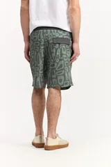 Short de baño estilo surf color gris, de largo medio, con estampado geométrico abstracto y cordón ajustable en la cintura. Incluye bolsillo trasero con solapa.