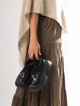 Mocasines negros de cuero con cordones y plataforma gruesa.