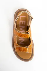 Sandalias de cuero color caramelo con textura efecto cocodrilo, suela chunky marrón y tiras ajustables con velcro.