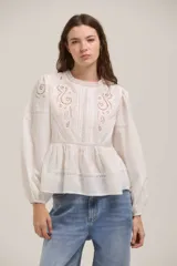Blusa de algodón color blanco con diseño romántico, cuello redondo, mangas largas abullonadas con puños elásticos y detalles de bordado inglés y encaje en el frente y hombros.