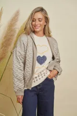 Campera estilo bomber abierta, confeccionada en tejido satinado con diseño matelasse en zigzag de color gris. Presenta terminaciones de pana fina en el escote y mangas largas.