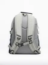 Mochila color arena con detalles en gris y negro. Cuenta con un compartimento principal con cierre, un bolsillo frontal con cordón elástico y bolsillos laterales de malla.