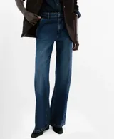 Jeans de tiro medio y corte wide leg, confeccionados en denim de algodón azul oscuro con lavado uniforme. Presentan cierre frontal con botón y cremallera, bolsillos laterales y traseros, y trabillas para cinturón.