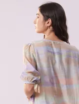 Blusa de gasa estampada con cuello a la base, escote en V plisado y lazo de ajuste. Delantera con detalles en puntilla y manga corta con puño fruncido.