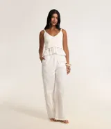 Pantalón recto de laise blanco con textura de perforaciones, cintura elástica con cordón ajustable y bolsillos laterales.