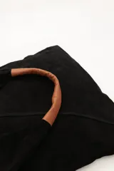 Bolso tipo tote de cuero color bordó, con asas de cuero color marrón.