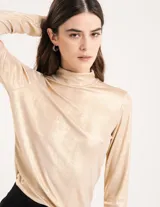 Polera dorada de cuello alto y manga larga, confeccionada en tejido elastizado con terminación metalizada.