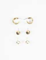 Set de tres pares de aros dorados con cierre de poste: un par de aros tipo argolla gruesa, un par de aros con forma irregular y un par de aros colgantes con forma circular irregular.