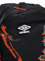 Mochila azul marino con diseño gráfico de salpicaduras en verde lima y letras blancas y verdes que forman la palabra "Umbro" verticalmente. Incluye el logo de Umbro en la parte superior central.