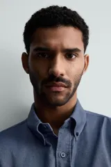 Camisa de corte regular fit confeccionada en tejido de algodón con efecto lavado. Presenta cuello abotonado, manga larga con puños abotonados, bolsillo en el pecho y cierre frontal con botones.