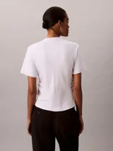 Remera Calvin Klein de manga corta y cuello redondo, color blanco, confeccionada en algodón pima. Presenta costuras verticales en el frente y un sutil logo script de la marca bordado en el pecho.