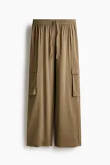 Pantalón cargo de tejido liviano color verde militar, con cintura elástica y cordón ajustable. Presenta diseño de piernas holgadas y bolsillos laterales con solapa.