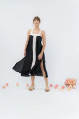 Vestido midi negro con panel frontal blanco, de corte amplio, escote recto y tiras anchas.