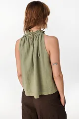 Blusa de lino italiano color marrón oscuro, con corte en línea A, hombros descubiertos, escote halter con frunces y volado en el cuello.