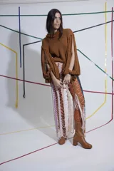 Sweater tejido a mano color marrón, con cuello alto y mangas con aberturas.