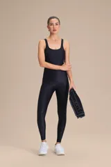 Jumpsuit largo de entrenamiento color negro, con diseño de una sola pieza, escote redondo y tirantes anchos. Confeccionado en tejido con ligero brillo y compresión media.