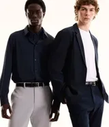 Pantalón de vestir gris claro, corte slim, con trabillas para cinturón, cierre tradicional, bolsillos laterales y traseros.