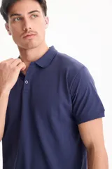 Chomba de piqué color blanco, con cuello polo y cierre frontal con tres botones.