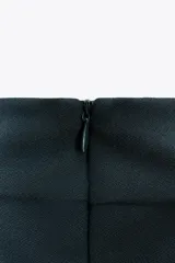 Top negro de cuello halter con cierre de botones en la parte trasera del cuello y espalda descubierta.