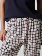 Pijama compuesto por una remera de manga corta color celeste con estampa frontal y un pantalón largo de corte recto con estampado de rayas verticales en tonos neutros.