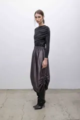 Top negro de mangas largas con frunces en el hombro izquierdo.