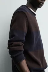 Jersey de punto de algodón con ajuste relajado, cuello redondo y manga larga. Presenta un diseño de rayas horizontales anchas en tonos azul marino y marrón oscuro.