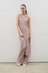 Vestido midi de diseño plisado en color rosado, con cuello alto y sin mangas. Presenta un tajo lateral y corte holgado, diseñado para ser usado en conjunto con pantalones del mismo tejido.