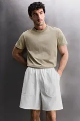 Pantalones cortos tipo jogger de corte relajado confeccionados en tejido de algodón. Presentan cintura elástica con cordón interior, bolsillos frontales en la cadera y un bolsillo trasero de plastrón.
