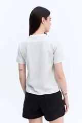 Remera de manga corta color gris melange, de calce regular y líneas simples, con detalles en contraste en el cuello y los puños.